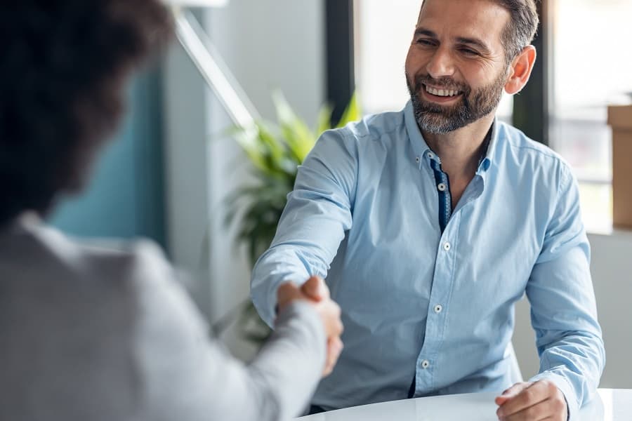 Real-estate agent shaking hands with client.